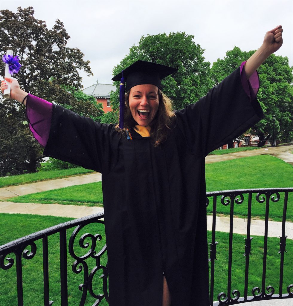 Smiling woman in graduation attire.